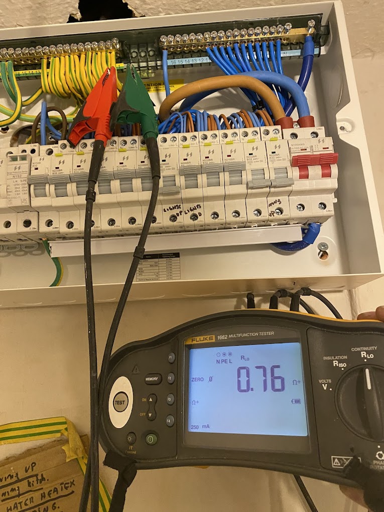 Electrician testing circuits at a consumer unit using a Fluke 1662 multifunction tester during an EICR in Dunstable